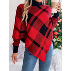 Woman holding a coffee cup while wearing a red and black plaid turtleneck poncho sweater