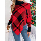Woman holding a white clutch while wearing a red and black plaid turtleneck poncho sweater