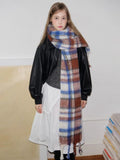 Woman wearing a plaid scarf and black leather jacket, with her hair down.