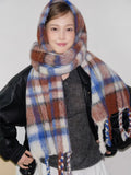 Close-up of a woman with a plaid scarf and hood.