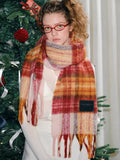 Close-up of a plaid scarf with a soft texture and fringed edges.