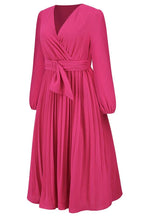 Side profile of a pink long-sleeved midi wrap dress with accordion pleats.