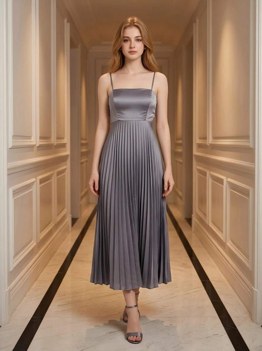 Woman wearing a gray satin midi dress with spaghetti straps and a square neckline, standing in a hallway.