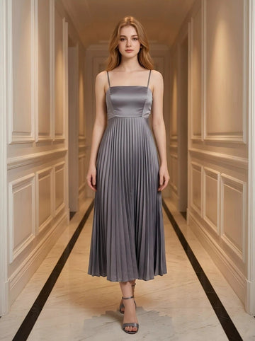 Woman wearing a gray satin midi dress with spaghetti straps and a square neckline, standing in a hallway.