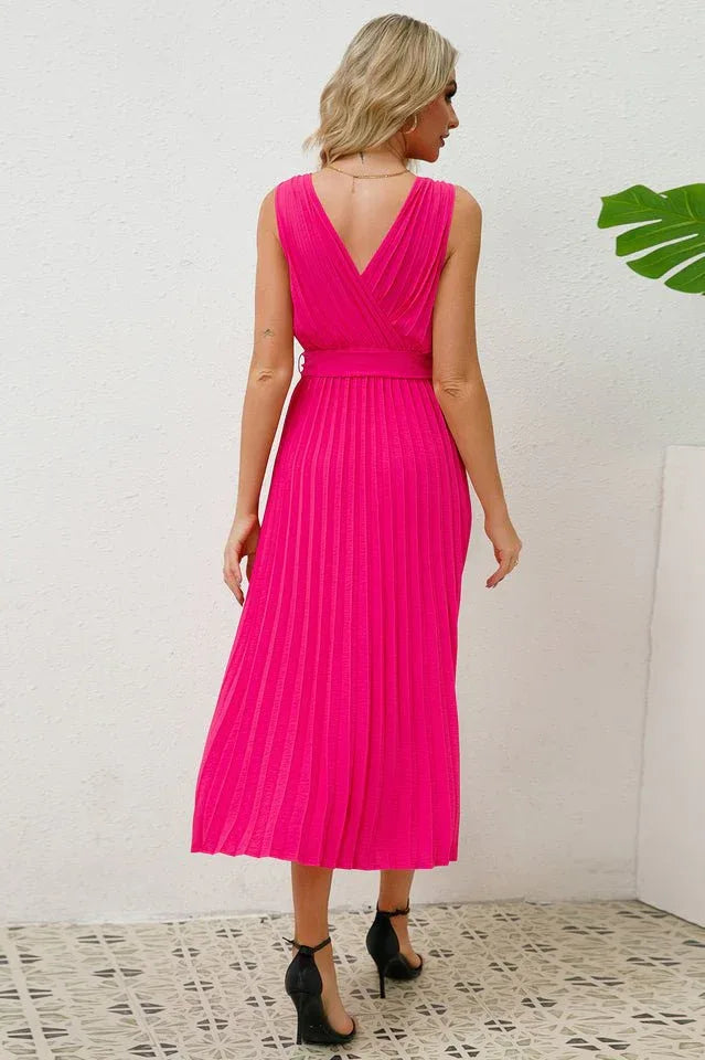 Back view of a woman in a bright pink sleeveless V-neck midi dress with a pleated skirt.
