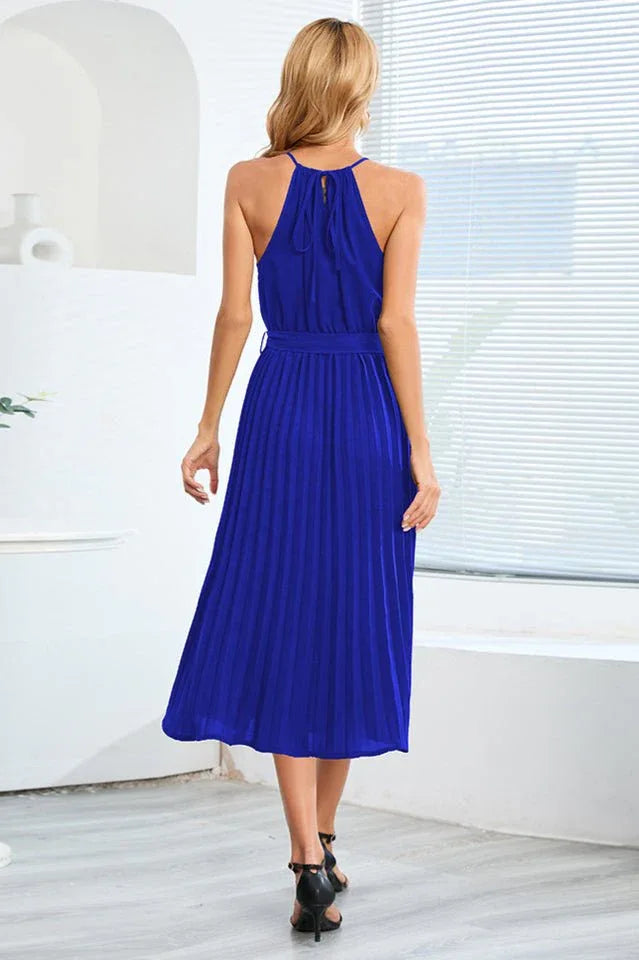 Back view of a royal blue pleated halter neck midi dress with a self-tie belt