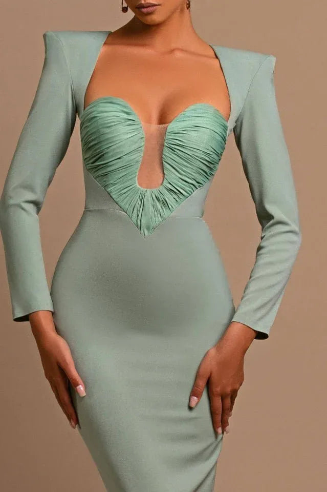 Full body shot of a woman in a sage green formal gown, showcasing its sleek silhouette and long sleeves.