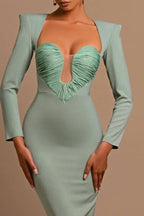 Full body shot of a woman in a sage green formal gown, showcasing its sleek silhouette and long sleeves.
