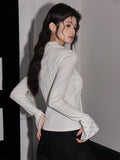 Rear view of the woman, demonstrating the fit and structure of the long-sleeve shirt.