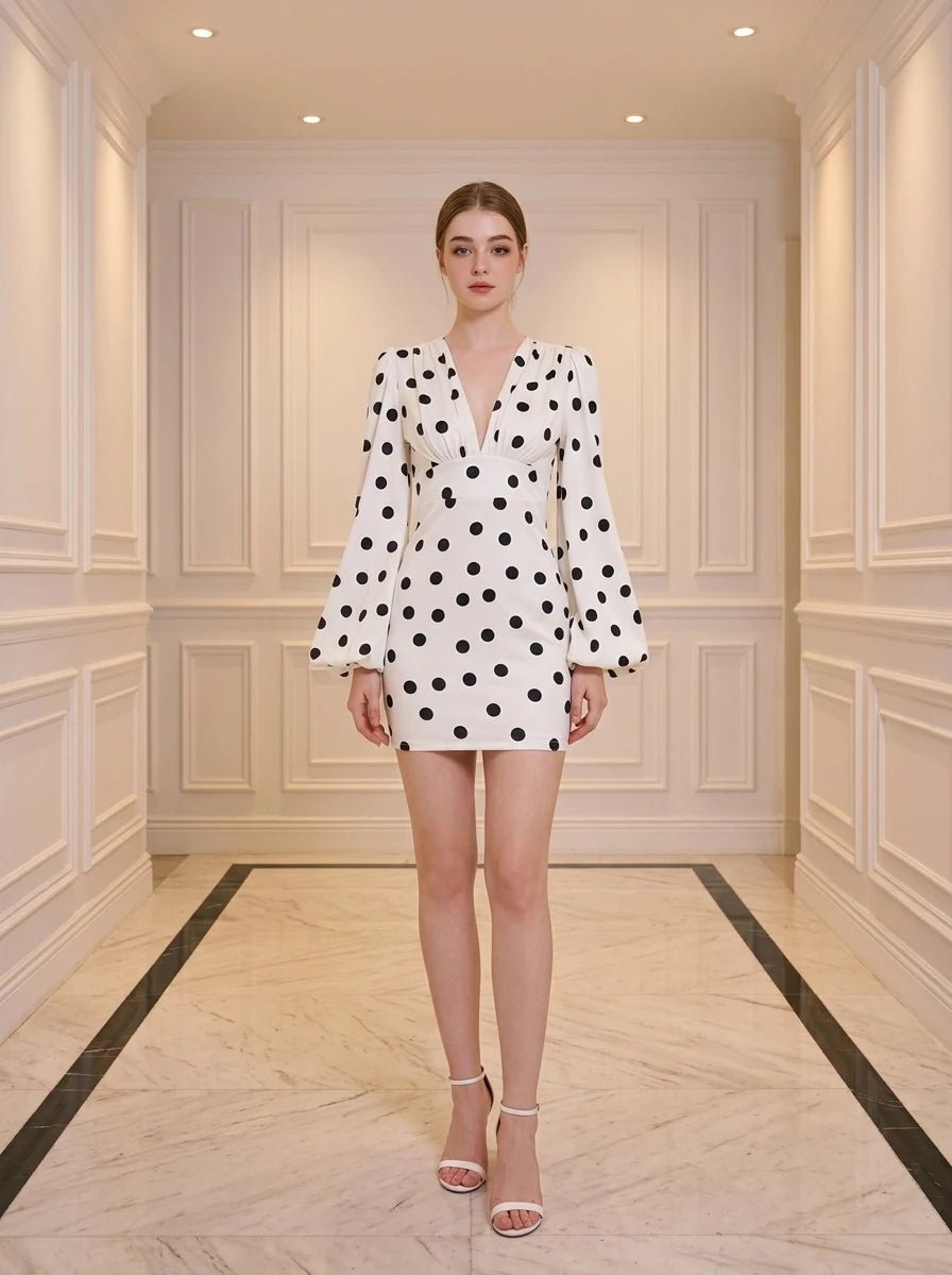 Woman wearing a white polka dot mini dress with plunging V-neck and bishop sleeves