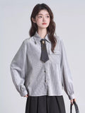 Close-up of a grey pinstripe blouse featuring a collared neckline and a decorative tie