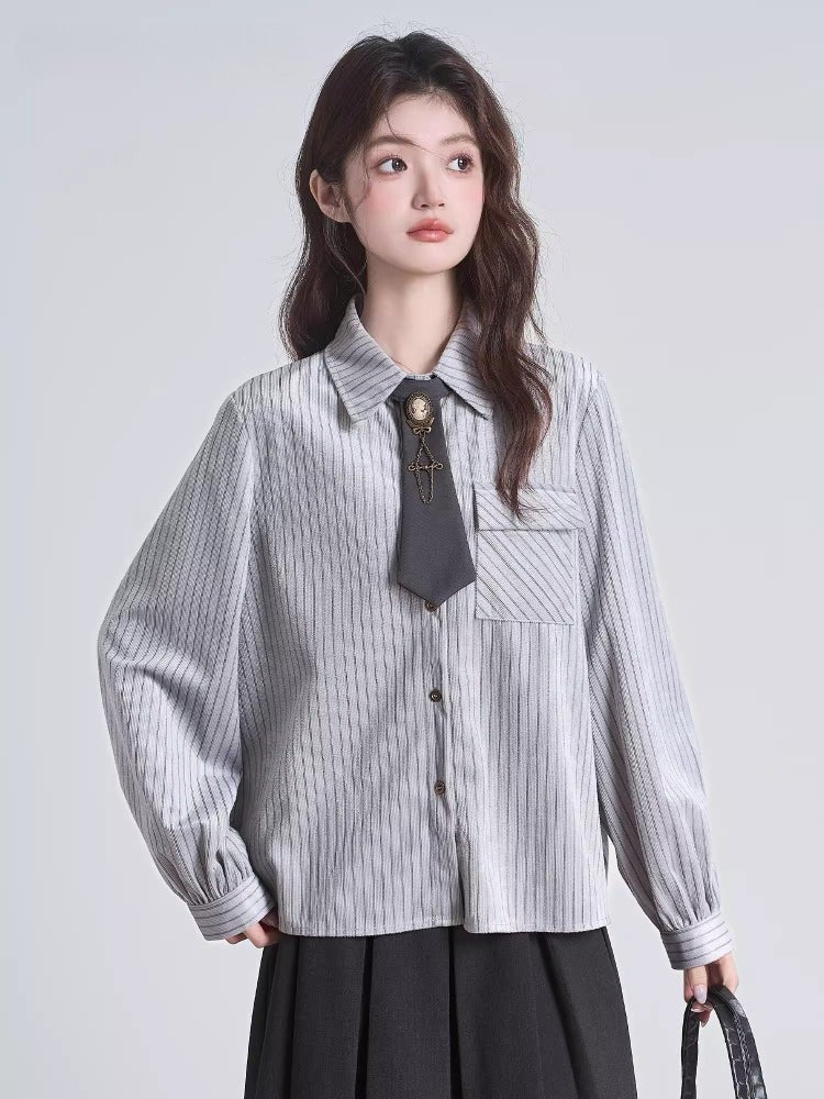 Close-up of a grey pinstripe blouse featuring a collared neckline and a decorative tie