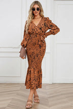 woman wearing a brown and black leopard print long sleeve smocked midi dress with a tie waist and ruffled hem