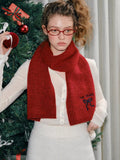Woman posing with a red knit scarf.