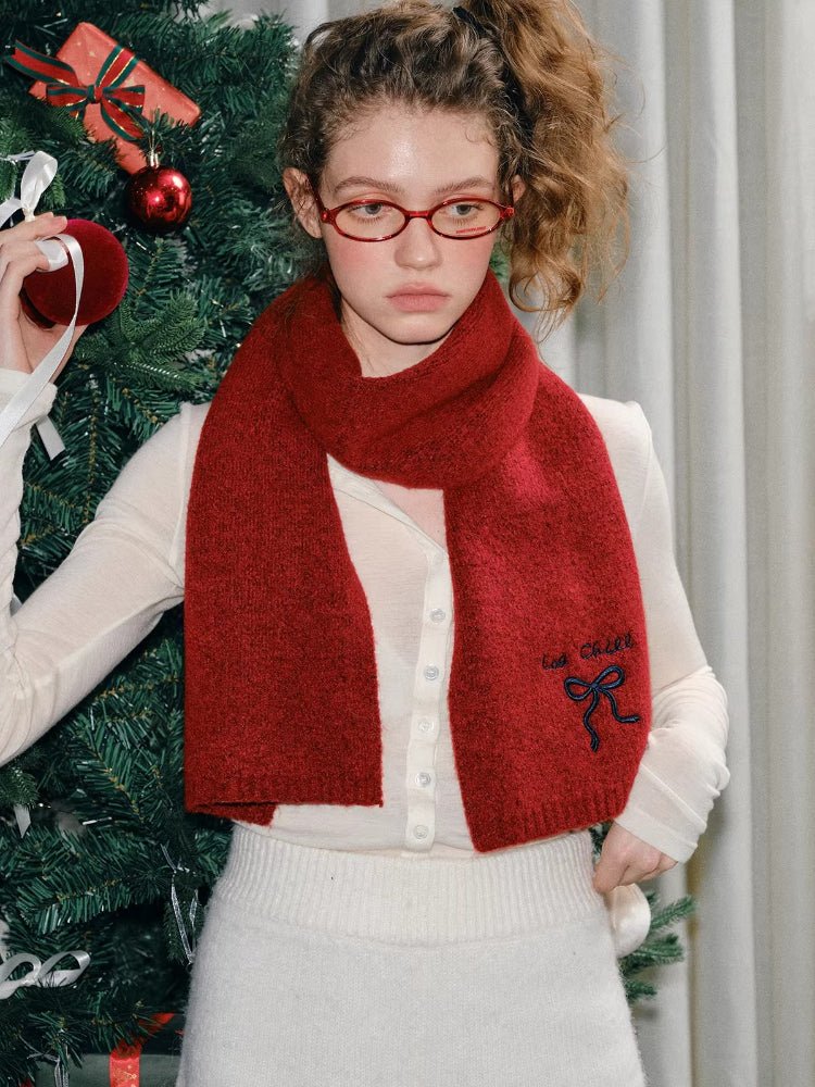 Woman posing with a red knit scarf.