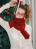 Model with a red knit scarf wrapped around her neck.