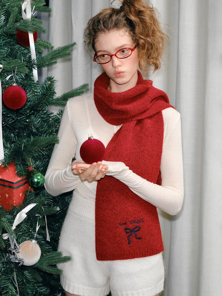 Detail of the red knit scarf's texture and embroidery.