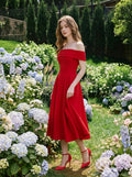 Woman in a red off-the-shoulder midi dress walking in a garden with hydrangeas.