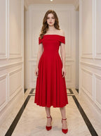 Woman wearing a red off-the-shoulder midi dress with cap sleeves.