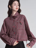 Close-up of the red and beige plaid cropped shirt featuring a small embroidered horse detail on the chest pocket.