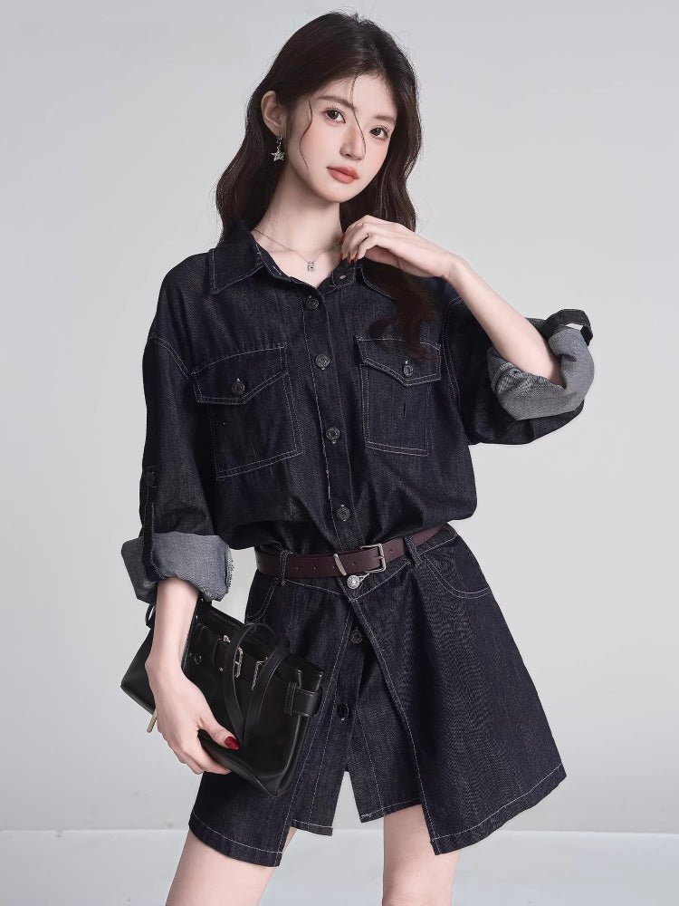 Woman in a dark wash denim shirt dress, holding a black handbag, with a brown belt cinching her waist.