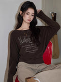 Close-up of a woman in a brown graphic print t-shirt with boat neck.