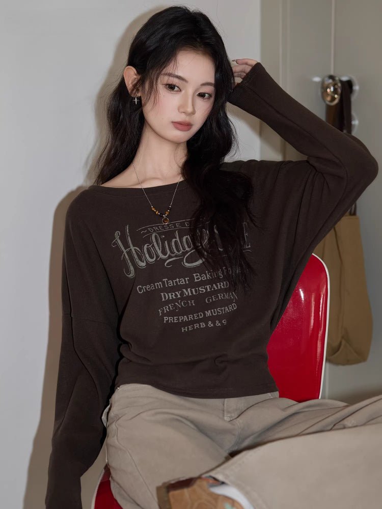 Close-up of a woman in a brown graphic print t-shirt with boat neck.