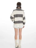 Back view of a woman wearing a grey and white striped knit sweater with a spread collar and zipper closure.