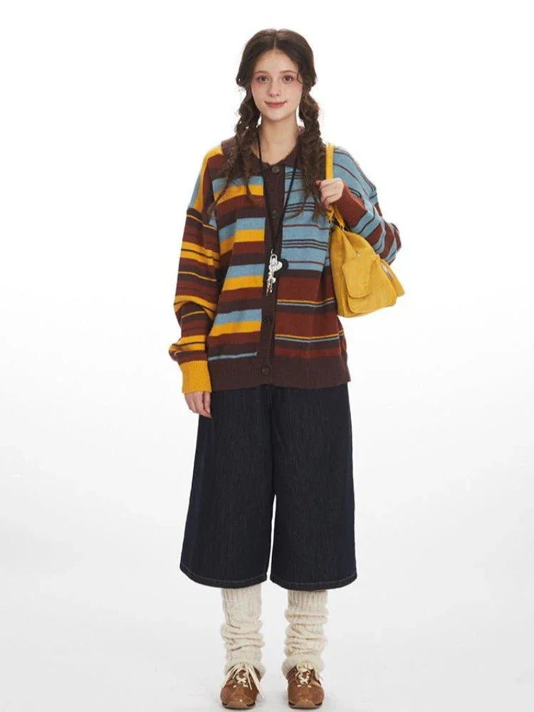 Woman wearing a striped knit cardigan over a dark top and wide-leg cropped pants, holding a yellow handbag.