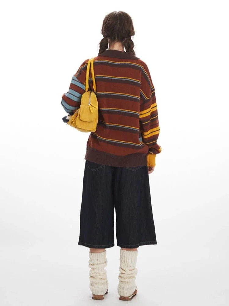 Back view of a woman in a striped knit cardigan, dark cropped pants, and light-colored leg warmers.