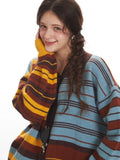 Close-up of a woman's face and shoulder, showcasing the texture and stripe pattern of the knit cardigan.