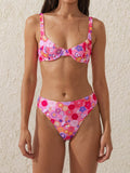 Woman wearing a pink floral print bikini with a sweetheart neckline and adjustable straps.