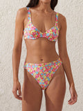 Woman wearing a colorful floral print bikini with a sweetheart neckline.