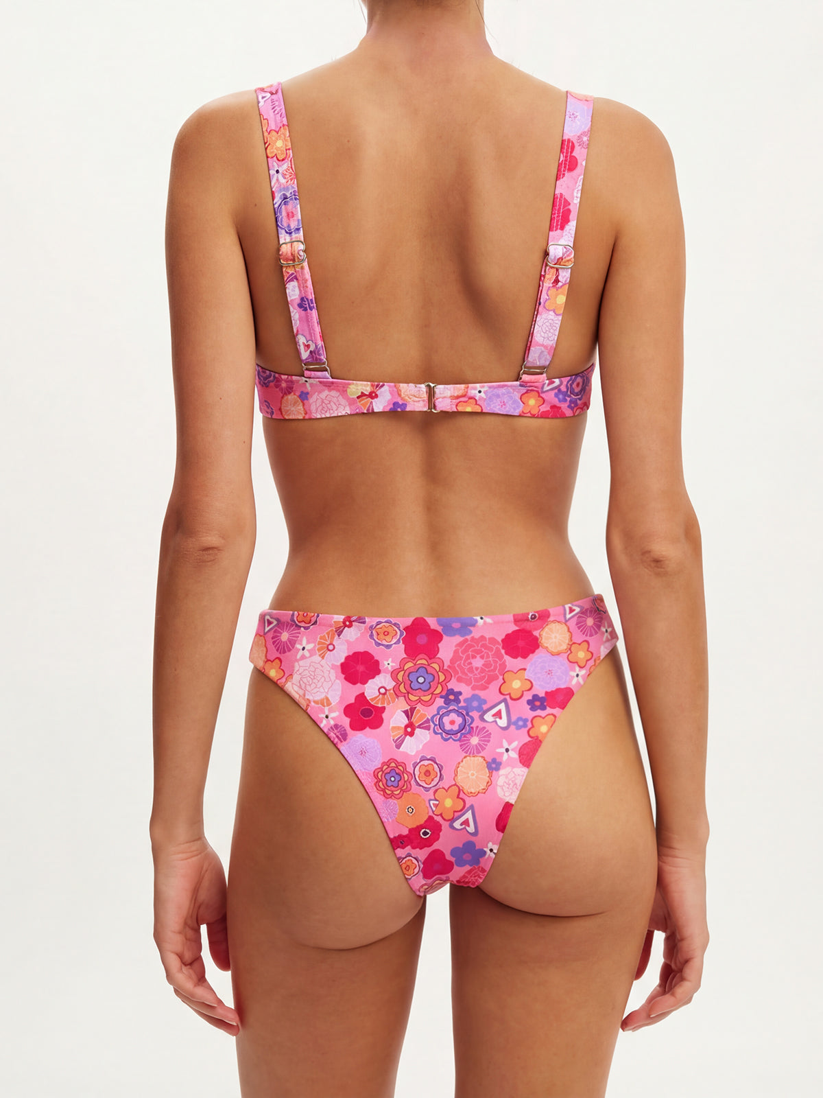 Back view of a woman wearing a pink floral print bikini, showing the clasp closure and adjustable straps.