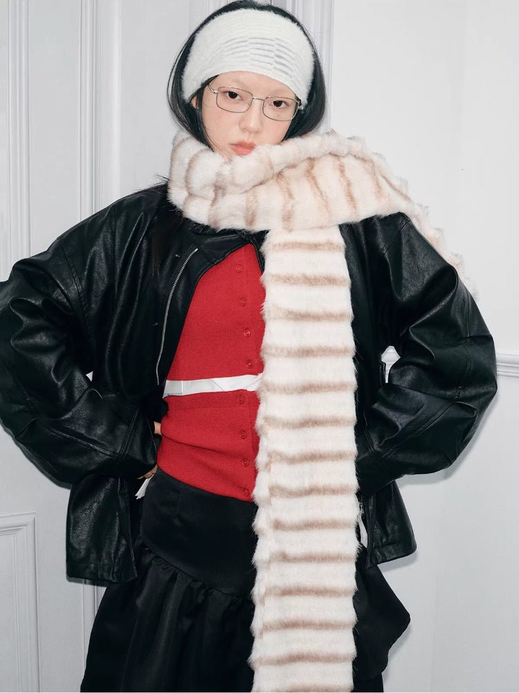 Model posing with hands on hips, wearing a striped faux fur scarf and a red cardigan.