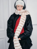 Close-up of a woman with a cream and brown striped faux fur scarf draped around her neck.