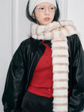 Profile shot of a person wearing a cream and brown striped faux fur scarf.
