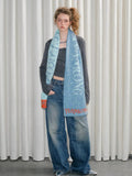 Close-up of a model with a textured scarf draped around their neck.