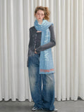 A fashion model poses with a vibrant, patterned scarf as a key accessory.