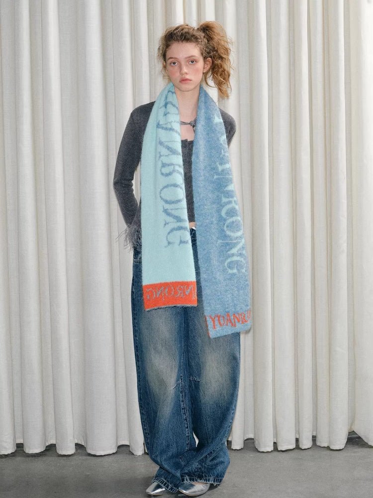 Full body shot of a person showcasing a long, wide scarf with printed text.