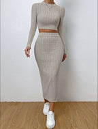 Front view of a woman in a beige ribbed knit outfit, styled with white sneakers and a white handbag.