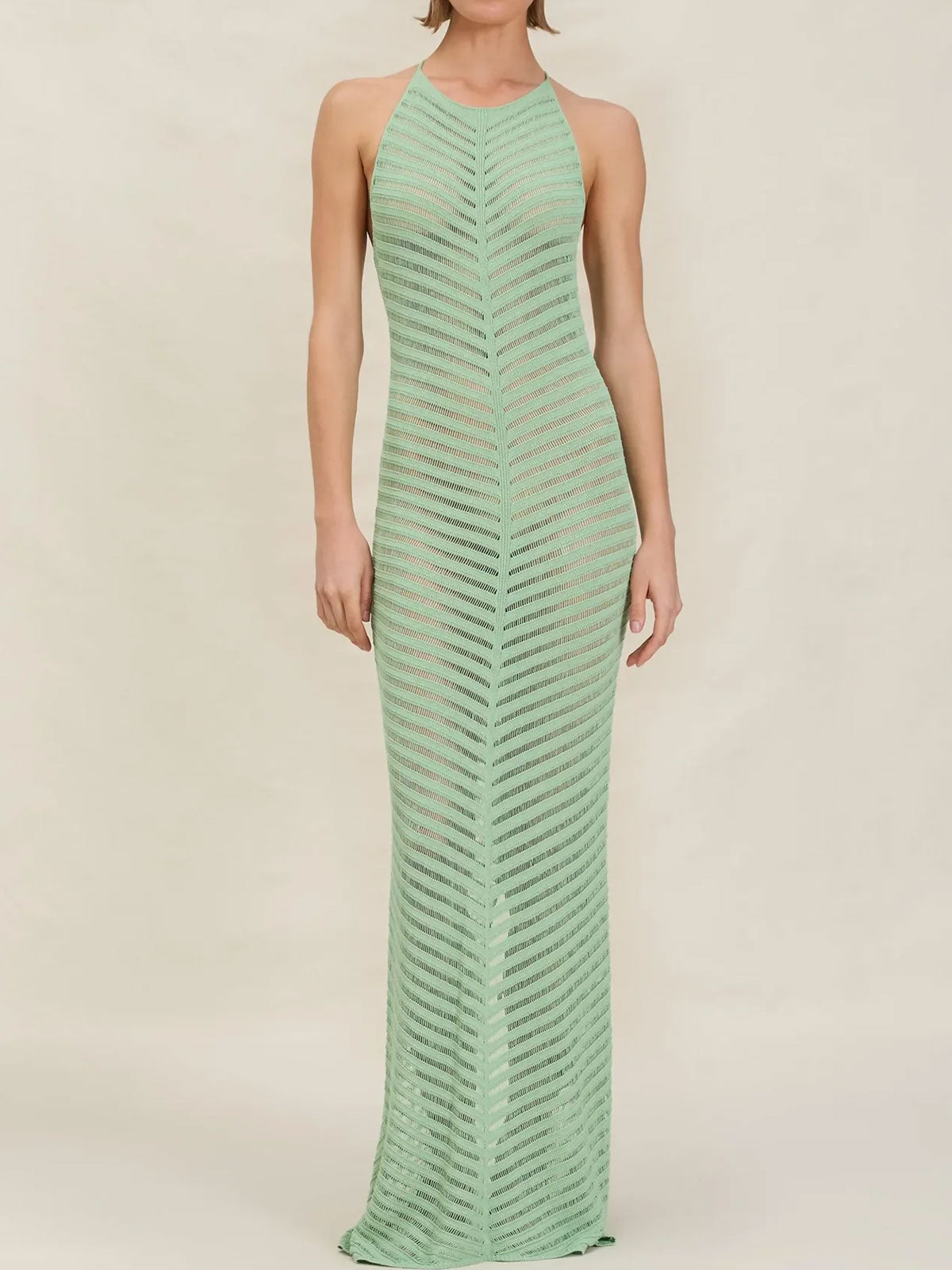 Woman wearing a mint green knit maxi dress with a halter neckline and chevron pattern