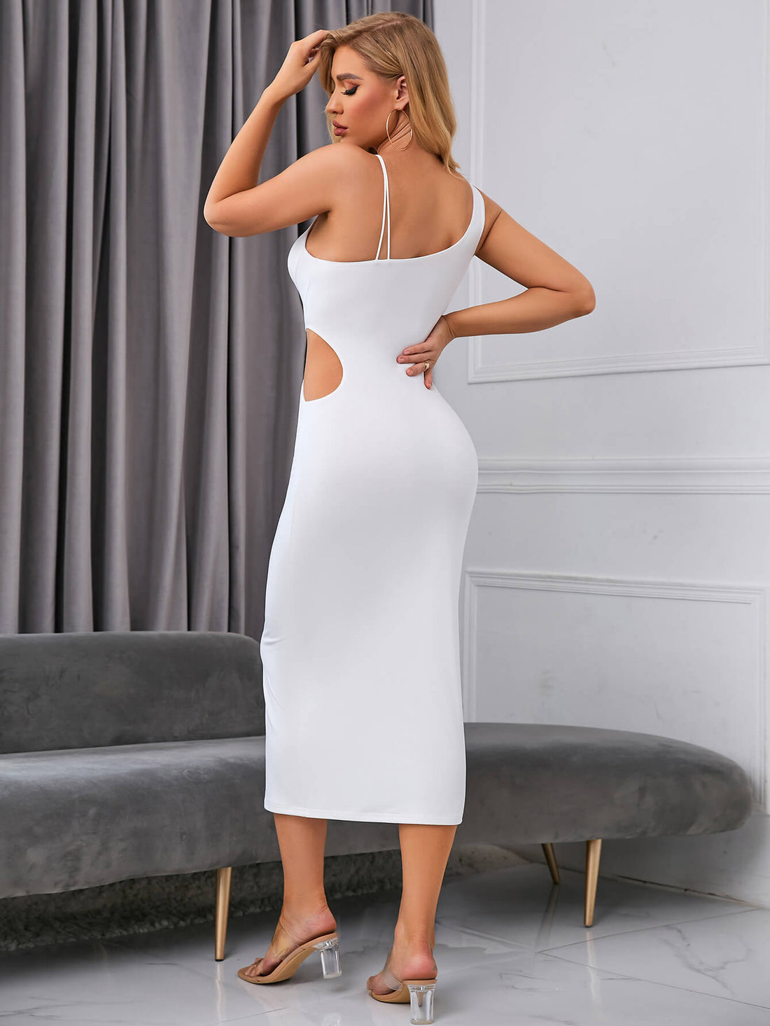 Woman wearing a white bodycon midi dress with cut-out details and ring hardware