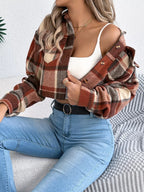 Front view of a woman in a plaid cropped shirt jacket and blue jeans