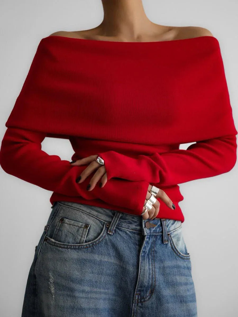 Woman in a red off-the-shoulder sweater and blue jeans.