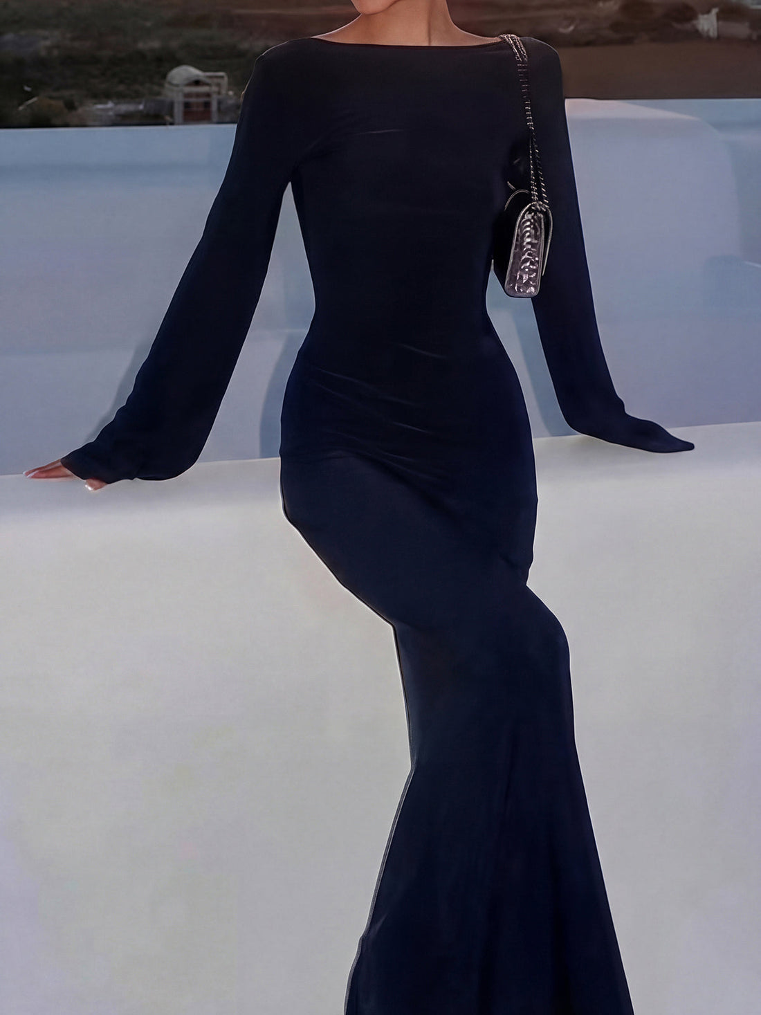 Woman wearing a white sheer knit maxi dress with bell sleeves on a yacht