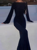 Woman wearing a black long-sleeved maxi dress with bell sleeves
