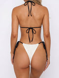 Woman wearing a cream triangle bikini with black string ties, back view