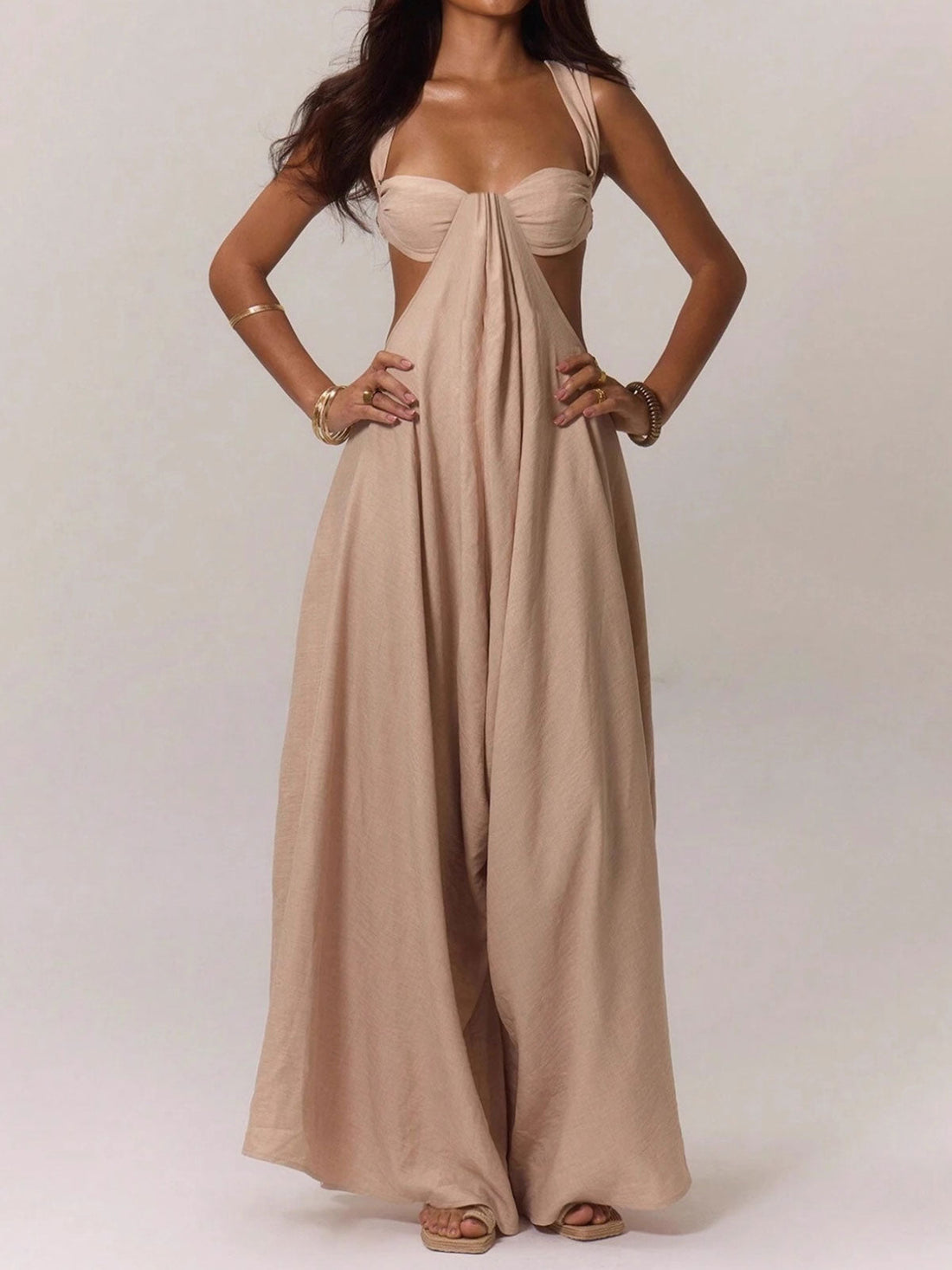 Woman wearing a beige linen blend jumpsuit with a strappy bralette top and wide legs, front view