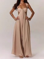 Woman wearing a beige linen blend jumpsuit with a strappy bralette top and wide legs, front view